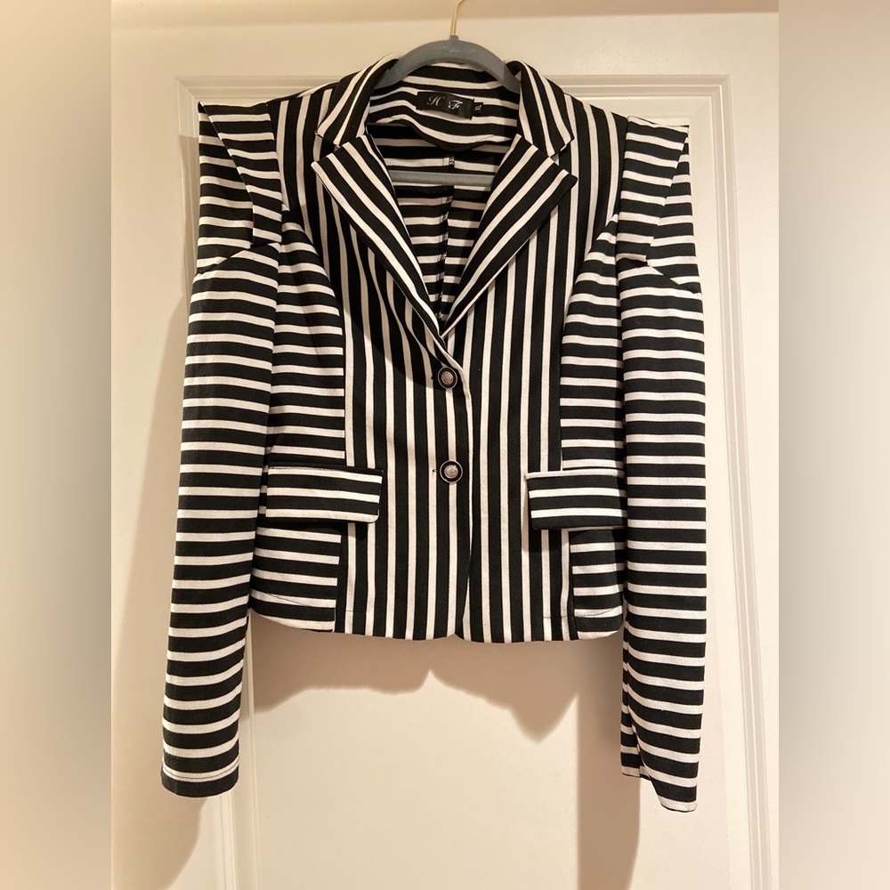 Structured blazer with detailed shoulder styling and stamped buttons.